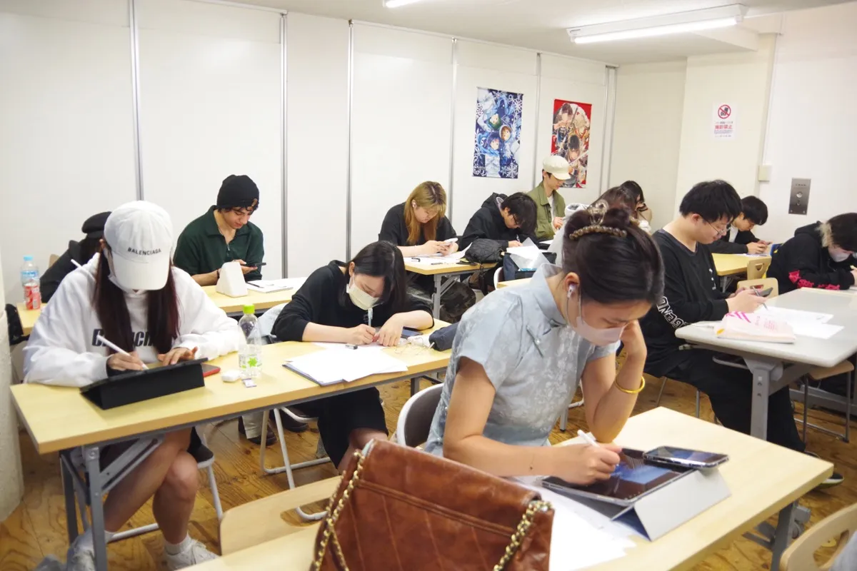 教室でタブレットに絵を描く学生たち