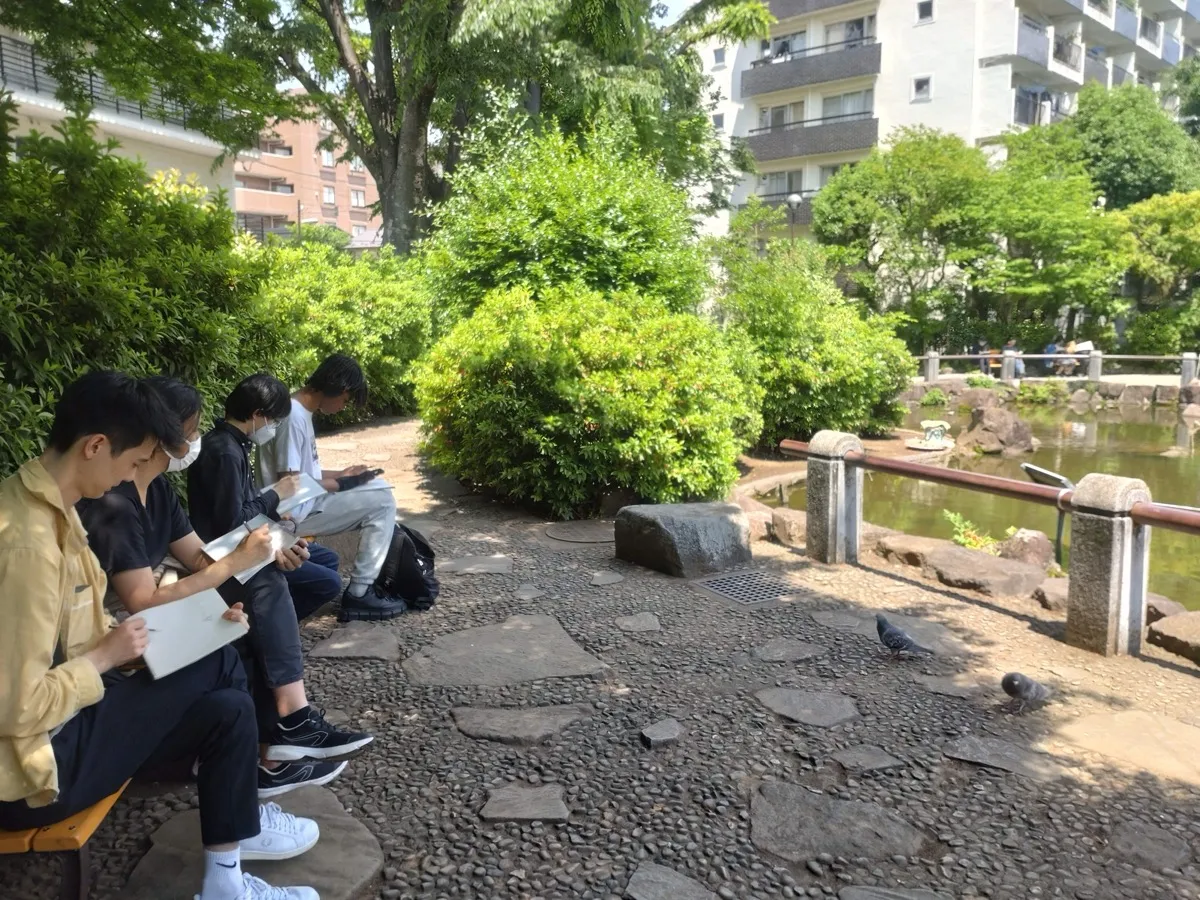 公園で学生たちが外でスケッチしている様子