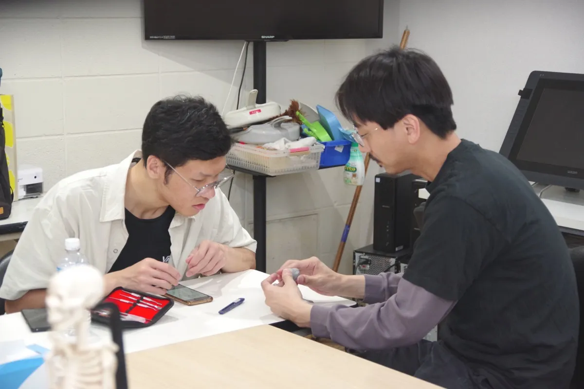 先生が学生の絵にアドバイスしている授業の様子